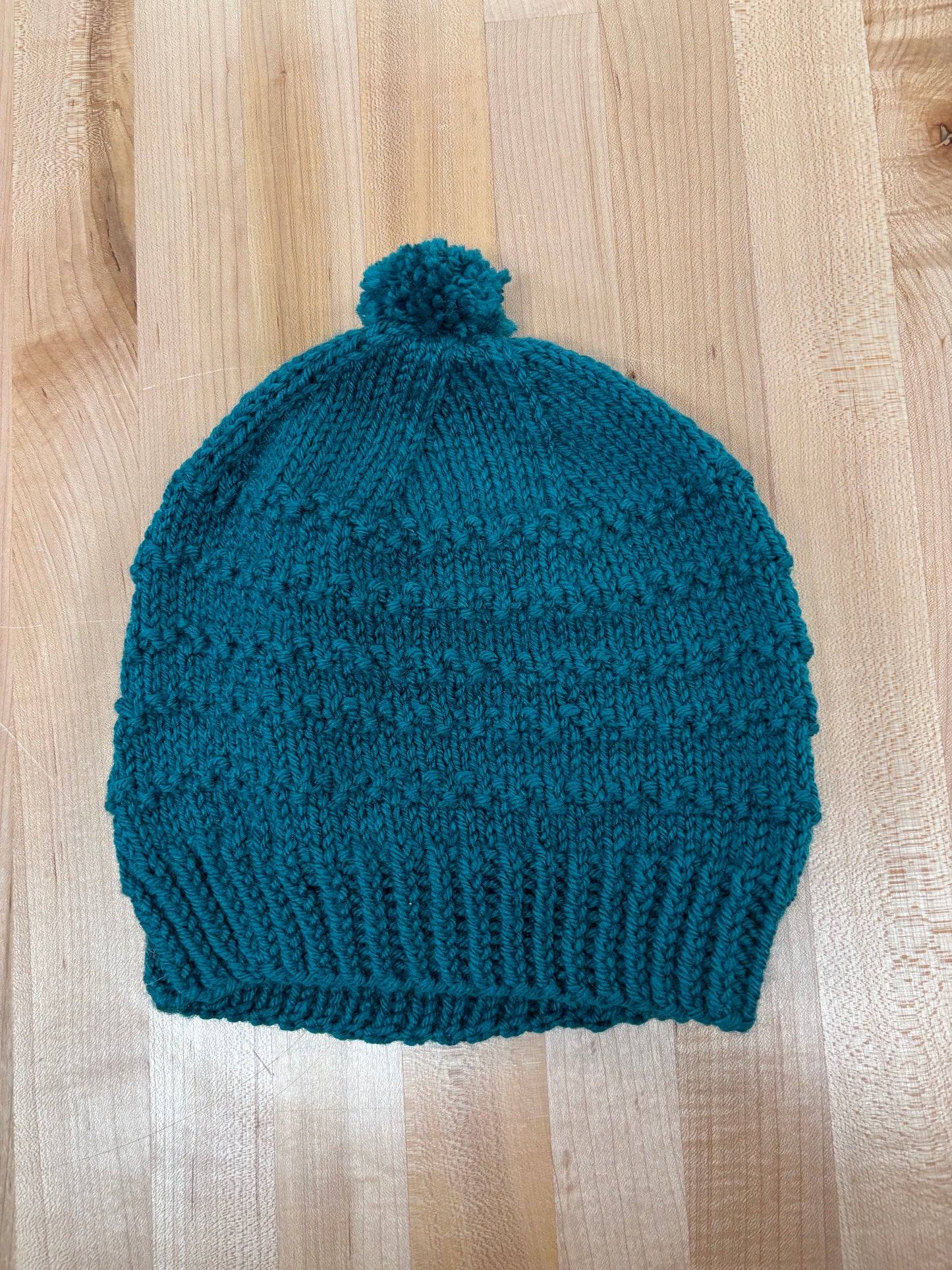 Hand knit winter hat with pom-pom