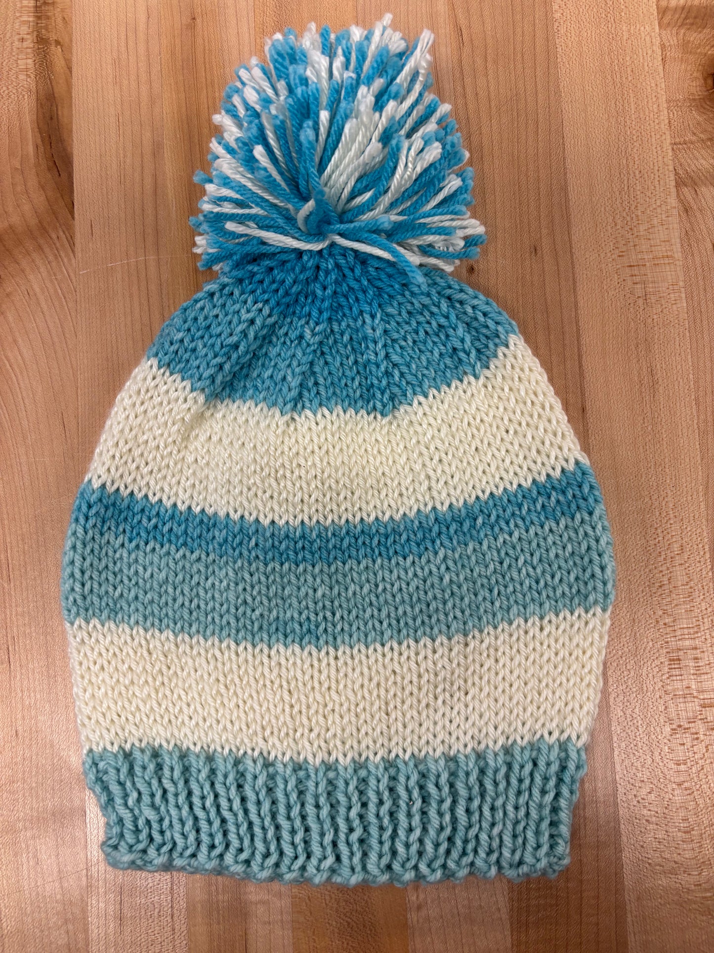 Hand knit winter hat with pom-pom